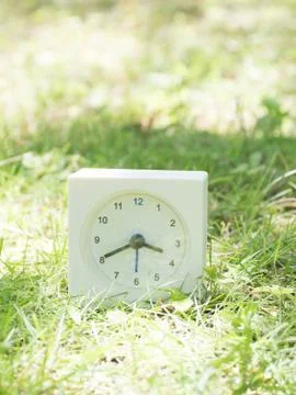 White simple clock on lawn yard, 3:40 three forty Stock Photos