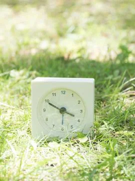 White simple clock on lawn yard, 3:50 three fifty Stock Photos