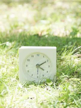 White simple clock on lawn yard, 4:10 four ten Stock Photos