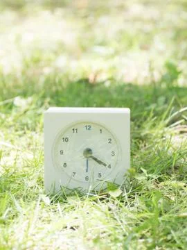 White simple clock on lawn yard, 4:20 four twenty Stock Photos