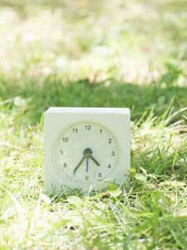 White simple clock on lawn yard, 4:35 four thirty five Stock Photos