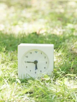 White simple clock on lawn yard, 5:45 five forty five Stock Photos