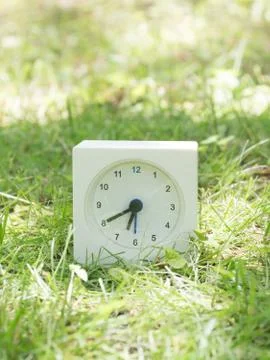 White simple clock on lawn yard, 6:40 six forty Stock Photos