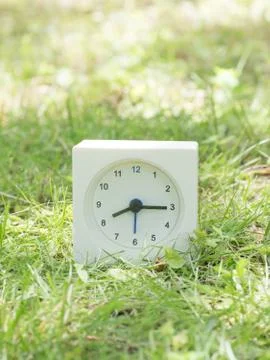 White simple clock on lawn yard, 8:15 eight fifteen Stock Photos