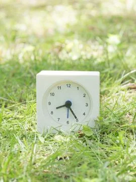 White simple clock on lawn yard, 8:25 eight twenty five Stock Photos
