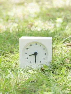 White simple clock on lawn yard, 8:30 eight thirty half Stock Photos