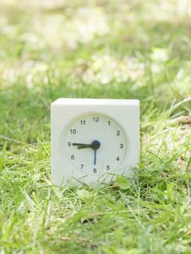 White simple clock on lawn yard, 8:45 eight forty five Stock Photos