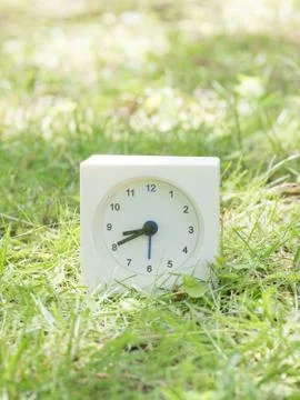 White simple clock on lawn yard, 8:40 eight forty Stock Photos