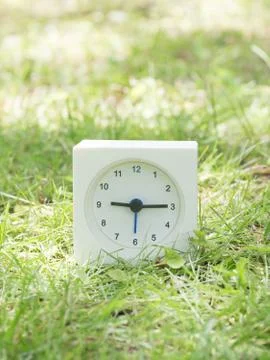 White simple clock on lawn yard, 9:15 nine fifteen Stock Photos
