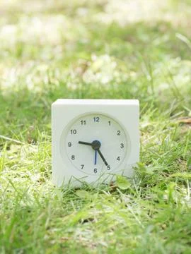 White simple clock on lawn yard, 9:25 nine twenty five Stock Photos