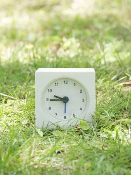 White simple clock on lawn yard, 9:45 nine forty five Stock Photos