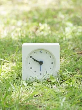 White simple clock on lawn yard, 9:50 nine fifty Stock Photos