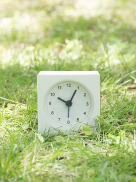 White simple clock on lawn yard, 10:05 ten five Stock Photos