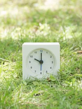 White simple clock on lawn yard, 10:00 ten o'clock Stock Photos