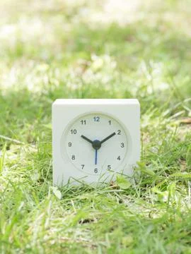 White simple clock on lawn yard, 10:10 ten ten Stock Photos