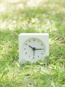 White simple clock on lawn yard, 10:15 ten fifteen Stock Photos
