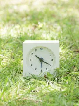 White simple clock on lawn yard, 10:20 ten twenty Stock Photos