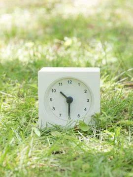 White simple clock on lawn yard, 10:30 ten thirty half Stock Photos