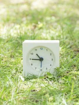White simple clock on lawn yard, 10:45 ten forty five Stock Photos