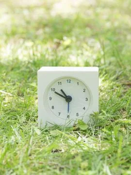 White simple clock on lawn yard, 10:50 ten fifty Stock Photos