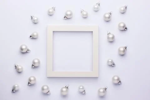 White simple frame with small christmas balls on a white background. Stock Photos
