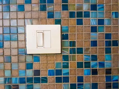 White single plastic switch on a tiled wall design Stock Photos