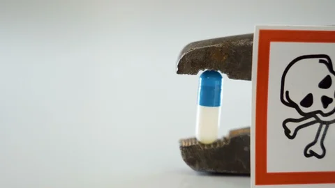 A white skull hazard sign on the side of the rusty pliers Stock Footage 129453382