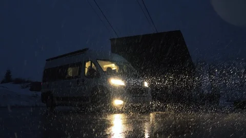 The white sleeping van parked in the middle of a snowstorm in winter. Stock Footage 112002904