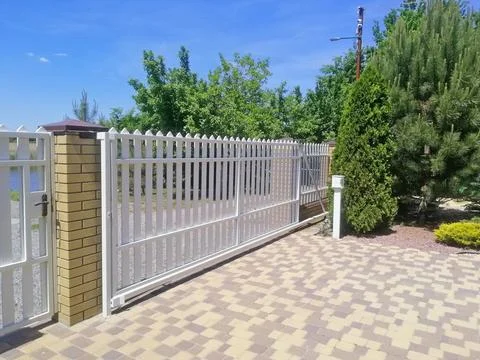 White sliding gate with brick pillars in private house entrance, showcasing.. Stock Photos
