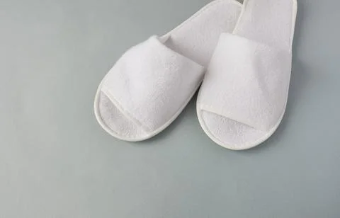 White slippers on a gray background, close-up, selective focus Stock Photos