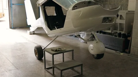White small aircraft under construction in workshop in airport service center. Video stock 120807042