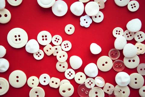 White small buttons on red background, flat lay Stock Photos