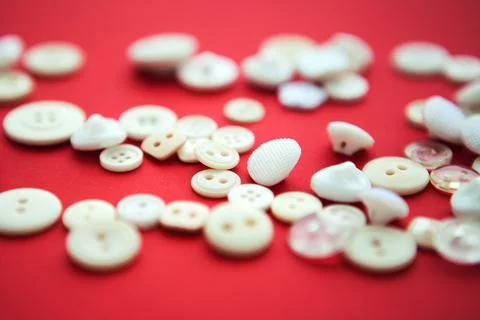 White small buttons on red background, close up Stock Photos