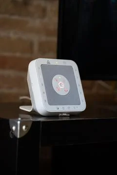 White smart home security hub displaying a central illuminated status light Stock Photos