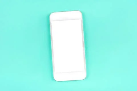 White smartphone on mint background. Stock Photos