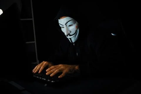 White smiling criminal anonymous mask installing virus encryption. Surmise. Stock-Fotos