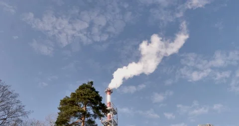 White smoke comes out of red and white boiler chimney and scatters across sky. 動画素材 238772443