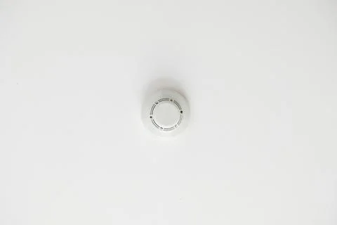 White smoke detector and fire alarm sensor on a ceiling Stock Photos
