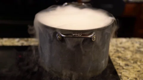 White Smoke Flowing Over Edges of Boiling Pot on Stove Stock Footage 70875855