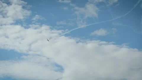 A white smoke loop pattern created by an aerobatic airplane in a clear blue sky Stock Footage 340394277
