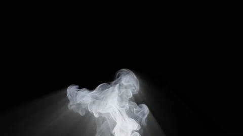 White smoke rises up from below and emits a magical glow against a black Stock Footage 239217289