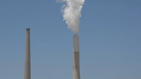 White smoke rises from the striped pipe into the blue cloudless sky on a bright, Видео 91440503
