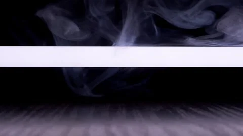 White Smoke Swirling Through Horizontal Light Beam In Dark Studio Vidéo 330116375