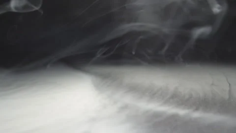 White smoke from the vape spreading on the floor. Black background Video stock 321306591