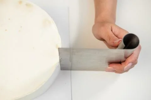 White smooth cylindrical cake blank. The confectioner creates the shape of a Foto stock