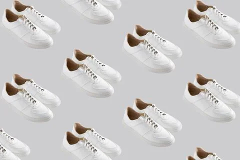 White sneakers pattern on a gray background. The shoes are comfortable and Stock Photos