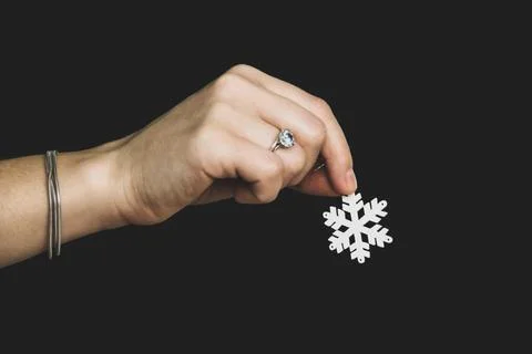 White snowflake in hand on a black background. Winter mood Stock Photos