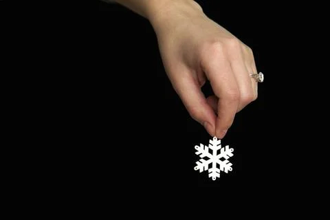 White snowflake in hand on a black background. Winter mood Foto stock