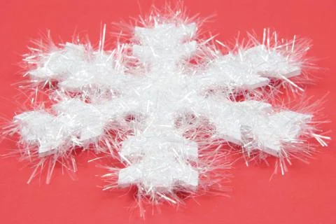 White snowflake on red background Stock Photos