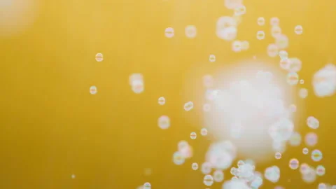 White soap bubbles flutter on a yellow background in slow motion Видео 137703676
